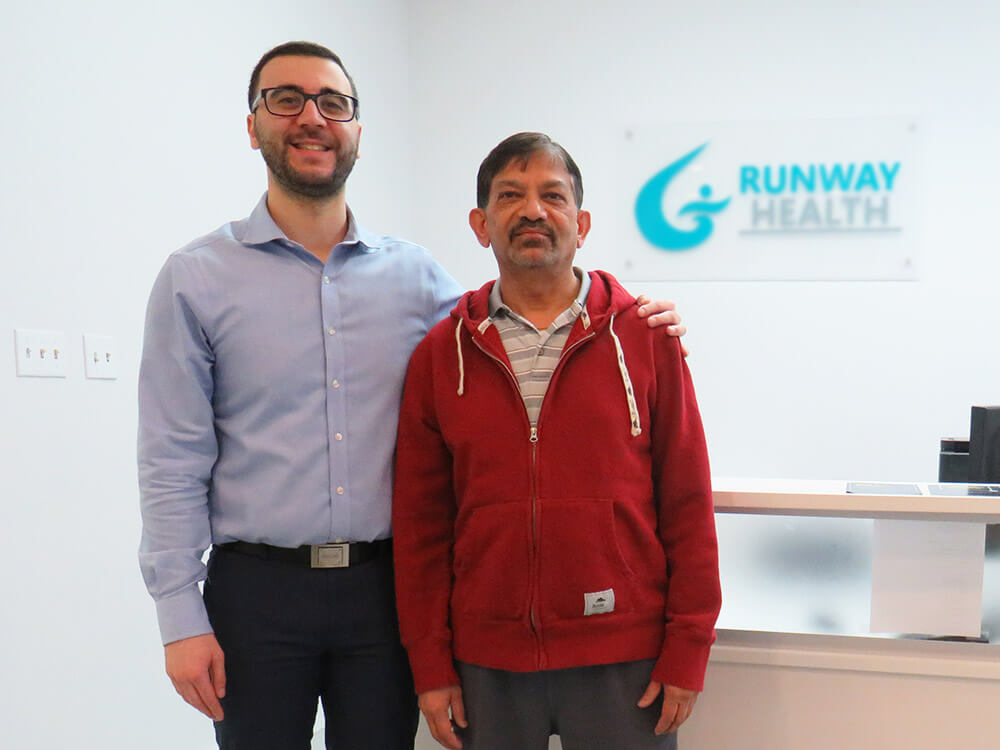 Dr. Omar, a chiropractor, is in reception with Harish, a patient who underwent laser enhanced knee decompression.