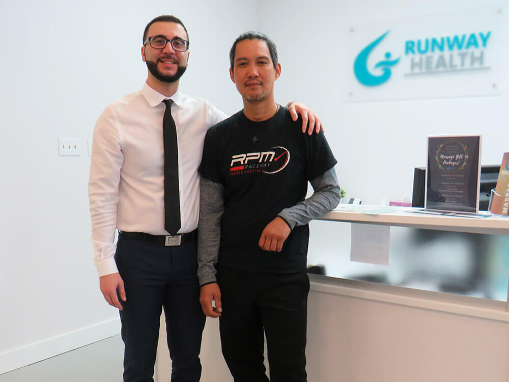 Dr. Omar, a chiropractor, is in reception with James, a long-time patient of the clinic.