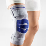 A person standing and wearing a orthoapedic knee brace on their right knee. The brace is a GenuTrain S Model of the brand Bauerfeind which is manufactured in Germany.