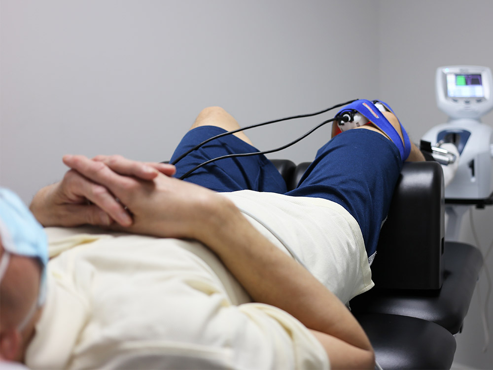 Man getting his right knee treated using the treatment modality, laser knee decompression.
