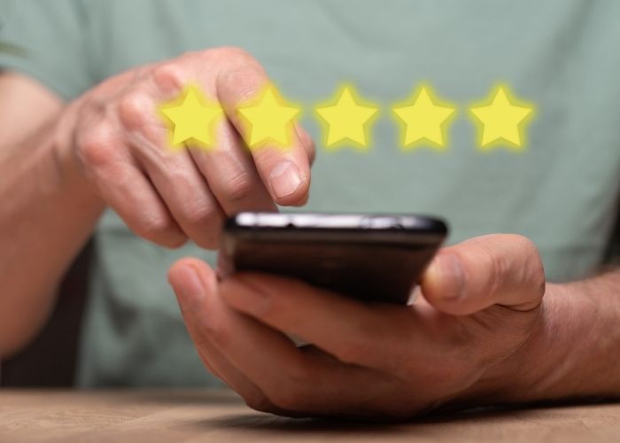 A man putting in a 5-star review on his phone. Runway Health has over 300 5-star reviews and has clinics in Markham and Newmarket.