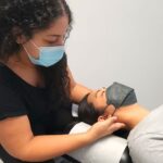 A chiropractor, Dr. Marina is providing a woman with manual traction to the cervical spine to help with decompressing the neck. This is a common technique used by chiropractors to reduce pain in the neck.